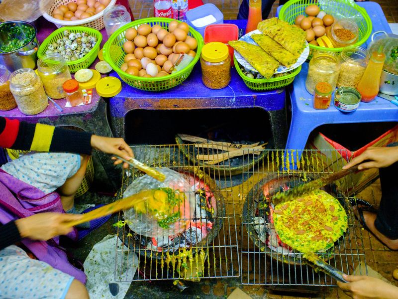 Banh trang nuong est une street food vietnamienne populaire : une galette de riz grillée, croustillante et garnie pour un encas rapide