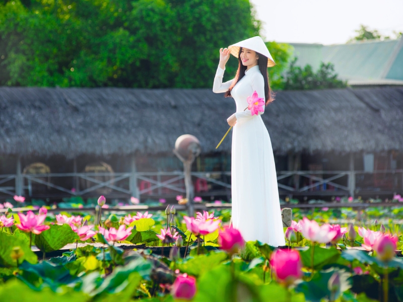 Ao Dai et Non La : l’élégance vietnamienne sublimée au bord d’un étang de lotus.